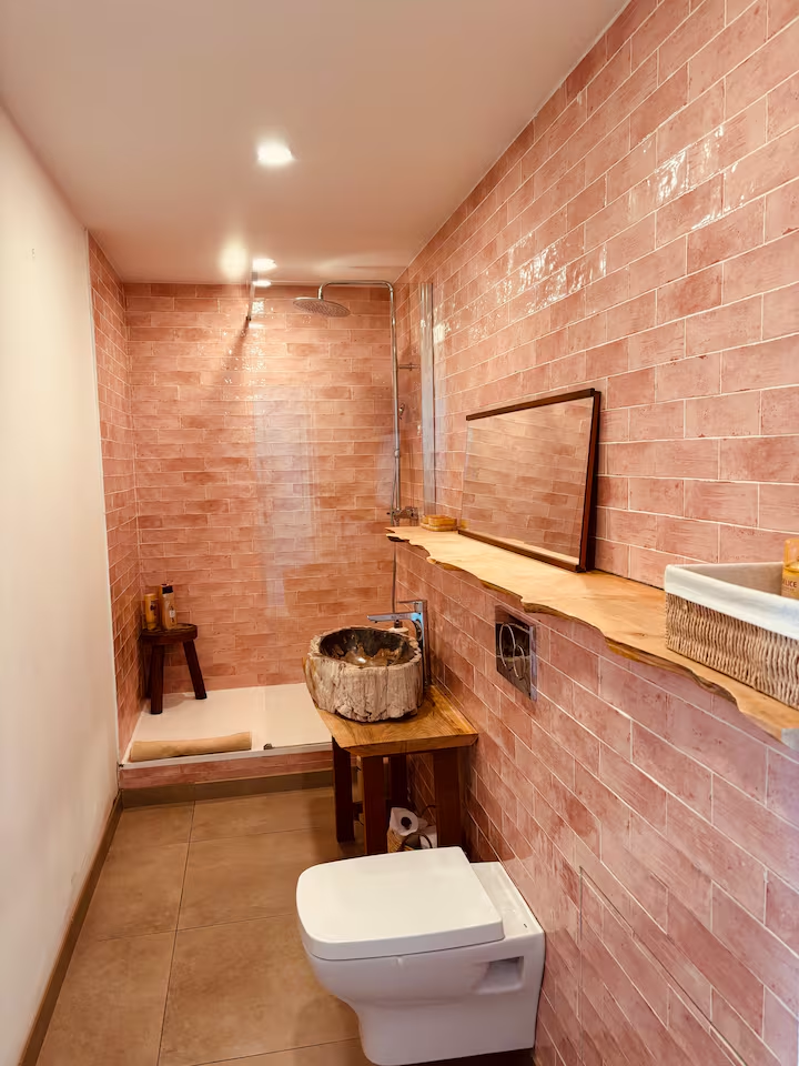 Shower room with terracotta tiles and petrified wood basin