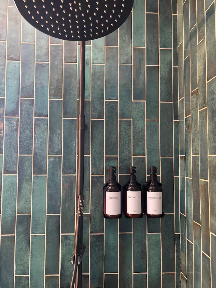 Rain shower with green zellige tiles and amenities